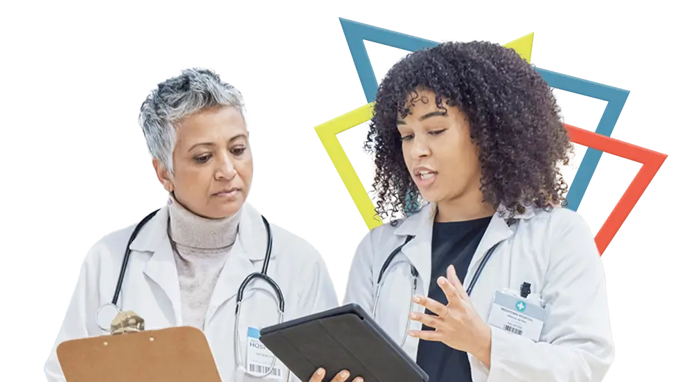Two doctors, both holding clipboards, in discussion about PEMAZYRE®'s safety profile.